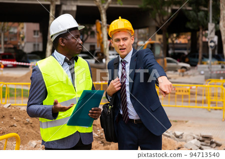 Architect tells engineer where to dig a trench to lay pipe Architect tells engineer where to dig a trench to lay pipe 94713540