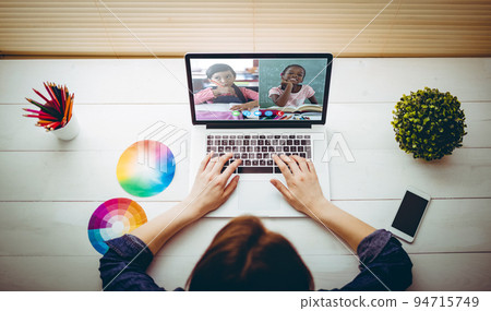 Caucasian girl sitting at desk using laptop to talk to friends Caucasian girl sitting at desk using laptop to talk to friends 94715749