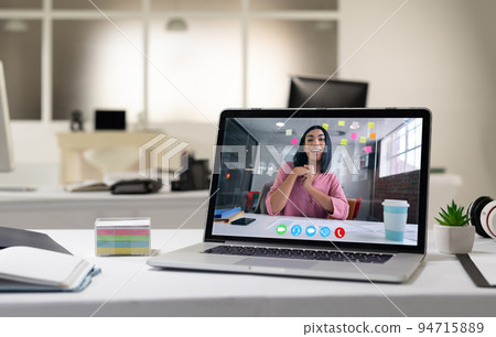 Mixed race woman having business video call on screen of laptop on desk 94715889