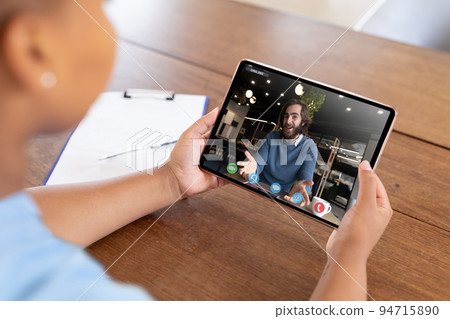 Caucasian woman using smartphone having video call with coworker 94715890