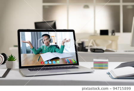 African american boy having video call on screen of laptop on desk 94715899