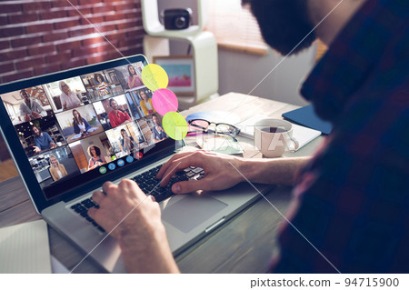 Caucasian man siting at desk, using laptop, having video call with coworkers 94715900