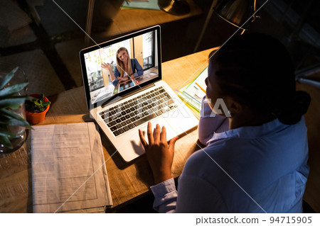 Caucasian woman sitting at desk having video call with coworker Caucasian woman sitting at desk having video call with coworker 94715905