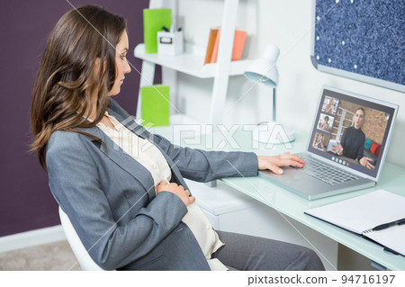 Caucasian businesswoman sitting at desk using laptop having video call with group of colleagues 94716197