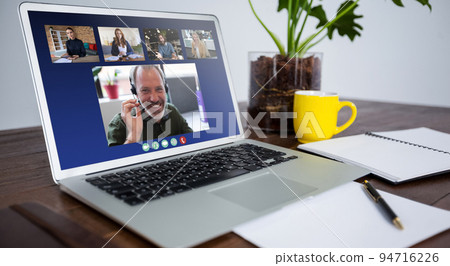 Laptop computer with a video call from businesspeople lying on desk Laptop computer with a video call from businesspeople lying on desk 94716226