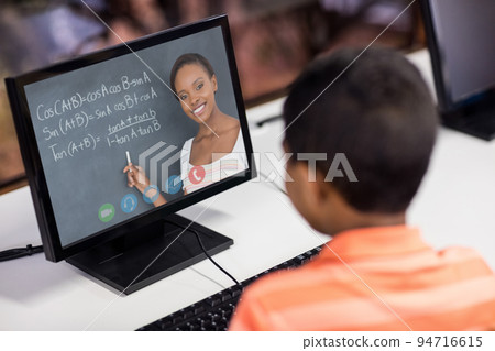 Mixed race schoolboy using computer on video call with female teacher Mixed race schoolboy using computer on video call with female teacher 94716615
