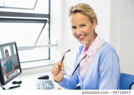Portrait of happy caucasian female teacher using computer on video call with schoolboy 94716647
