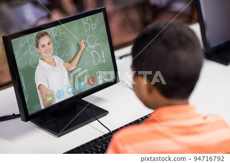 Male student having a video call with female teacher on computer at school Male student having a video call with female teacher on computer at school 94716792