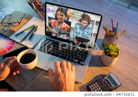 School children learning displayed on laptop screen during video call with male teacher School children learning displayed on laptop screen during video call with male teacher 94716831