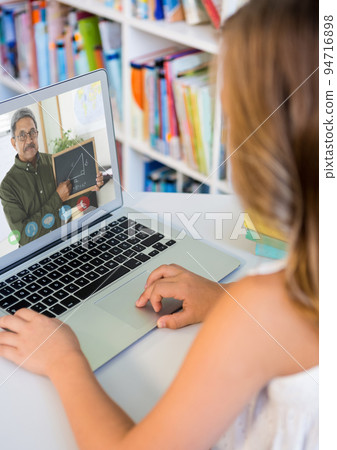 Caucasian schoolgirl using laptop on video call with male teacher Caucasian schoolgirl using laptop on video call with male teacher 94716898