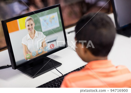 Mixed race schoolboy using computer on video call with female teacher Mixed race schoolboy using computer on video call with female teacher 94716900