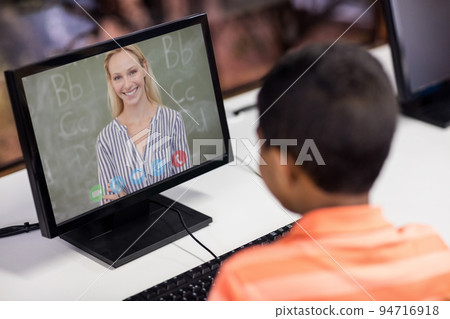 Mixed race schoolboy using computer on video call with female teacher Mixed race schoolboy using computer on video call with female teacher 94716918