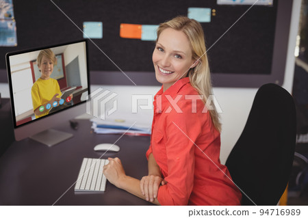 Portrait of smiling caucasian female teacher using computer on video call with schoolboy Portrait of smiling caucasian female teacher using computer on video call with schoolboy 94716989