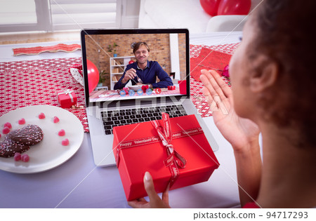 Diverse couple making valentines date video call on laptop woman blowing kiss to man eating Diverse couple making valentines date video call on laptop woman blowing kiss to man eating 94717293