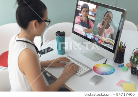 Caucasian female teacher using computer on video call with schoolgirls Caucasian female teacher using computer on video call with schoolgirls 94717400