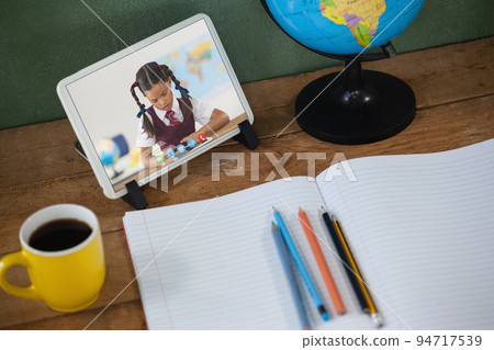 Caucasian schoolgirl learning on tablet screen on desk during video call Caucasian schoolgirl learning on tablet screen on desk during video call 94717539
