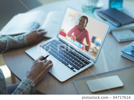 African american schoolgirl learning displayed on laptop screen during video call with female teache African american schoolgirl learning displayed on laptop screen during video call with female teache 94717616