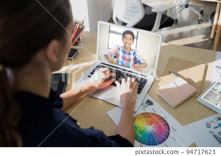 Female teacher having a video call with male student on laptop at school Female teacher having a video call with male student on laptop at school 94717623