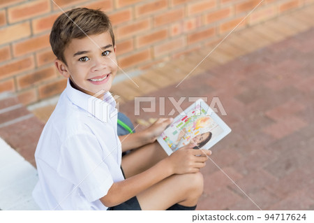 Portrait of male caucasian student having a video call with female teacher on digital tablet at scho Portrait of male caucasian student having a video call with female teacher on digital tablet at scho 94717624