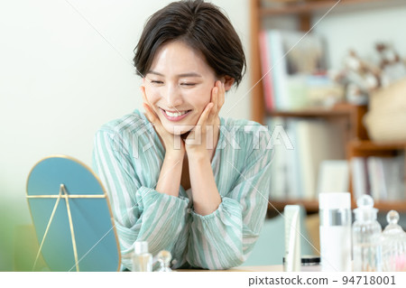 Woman looking in the mirror with a smile Woman looking in the mirror with a smile 94718001