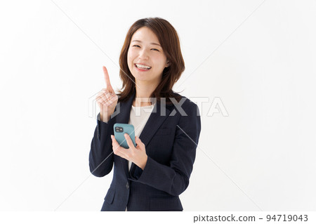 A woman in a suit holding a smartphone 94719043