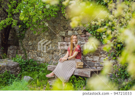 Woman tourist walks through the old town of Bar in Montenegro. Happy tourist walks in the mountains. Suburbs of the city of Bar, Montenegro, Balkans. Beautiful nature and landscape 94721033