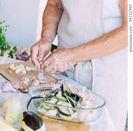 A woman is engaged in the preparation and processing of various fresh farm vegetables 94722465