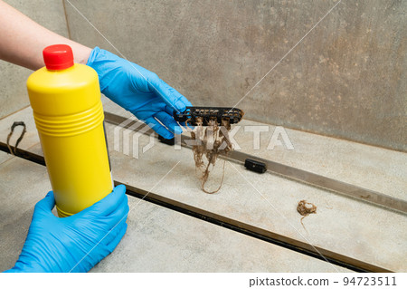 Woman using liquid drain cleaners to clean bathroom sink drain. Woman using liquid drain cleaners to clean bathroom sink drain. 94723511