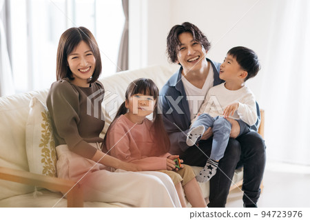 Smiling family sitting on the sofa/child-rearing image 94723976