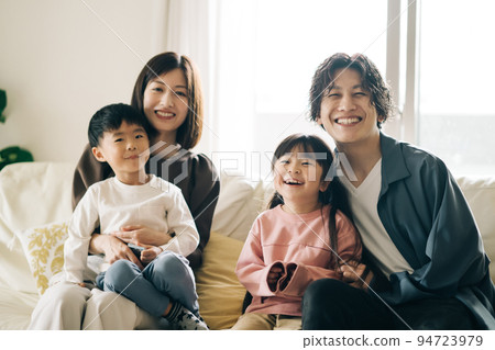 Smiling family sitting on the sofa/child-rearing image 94723979