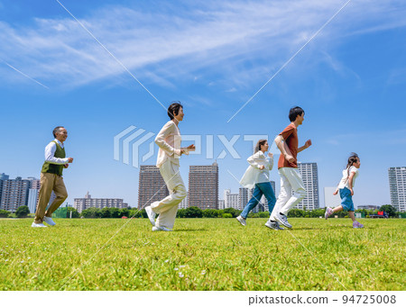 Three generations of family running in the park 94725008