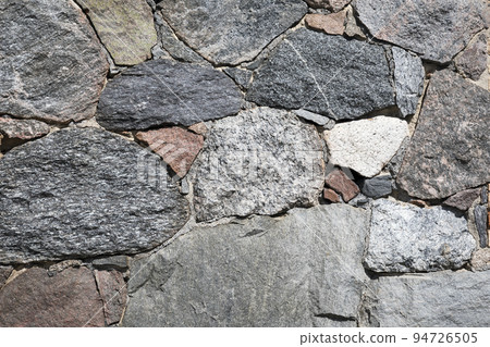 Stone wall with different colors and size of rocks 94726505