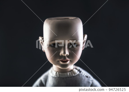 Creepy doll face on dark background 94726525
