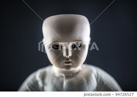 Creepy doll face on dark background 94726527