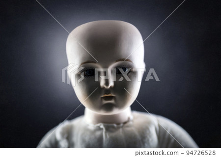 Creepy doll face on dark background 94726528