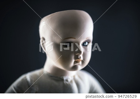 Creepy doll face on dark background 94726529