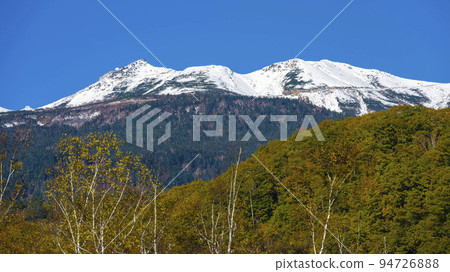 Norikura-dake covered with snow and autumn leaves 94726888