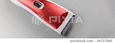 Electric hair machine for trimming hair, red colour design on grey surface 94727060