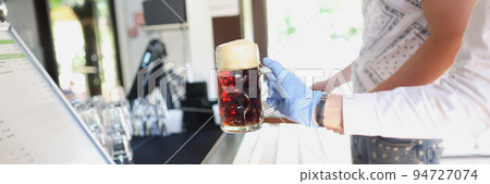 Waiter give glass with beer to client in protective glove, prevent covid spread Waiter give glass with beer to client in protective glove, prevent covid spread 94727074