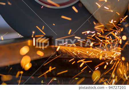 Worker cutting steel rectangular pipe in construction site. Worker cutting steel rectangular pipe in construction site. 94727201