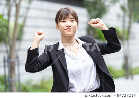 A woman in a suit posing for cheering A woman in a suit posing for cheering 94727217