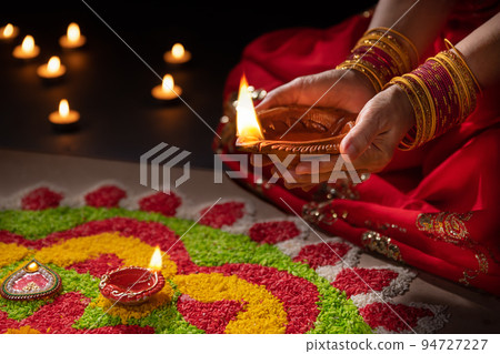 Traditional diya lamps lit during diwali celebration Traditional diya lamps lit during diwali celebration 94727227