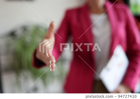 Office worker holds out hand for handshake Office worker holds out hand for handshake 94727410