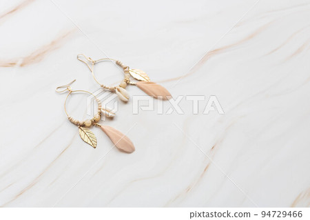 A pair of earrings on a marble background with copy space. A pair of earrings on a marble background with copy space. 94729466