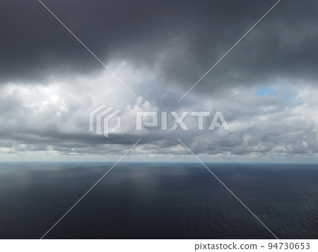 Abstract aerial nature summer ocean sunset sea and sky background. Small waves on clear water surface in motion blur with bokeh lights from sunrise. Holiday, vacation and recreational concept Abstract aerial nature summer ocean sunset sea and sky background. Small waves on clear water surface in motion blur with bokeh lights from sunrise. Holiday, vacation and recreational concept 94730653