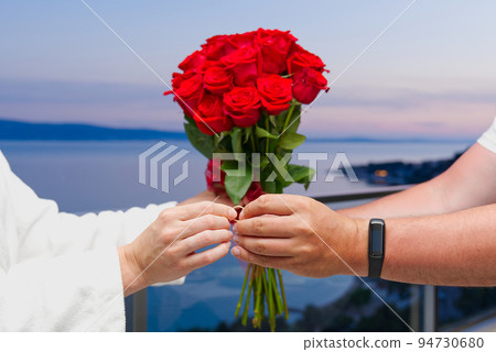 Man giving an engagement ring to his woman in hotel at vacation. unrecognizable 94730680