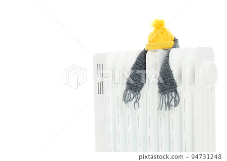 Electric heater with scarf and hat isolated on white background Electric heater with scarf and hat isolated on white background 94731248