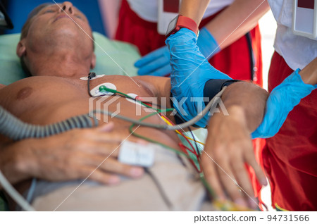 Paramedical staff checking the vital signs of an ill man Paramedical staff checking the vital signs of an ill man 94731566