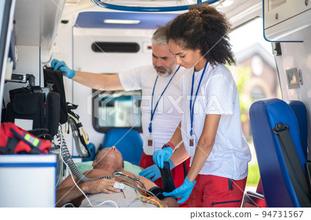 Team of paramedics checking the patient vital signs 94731567