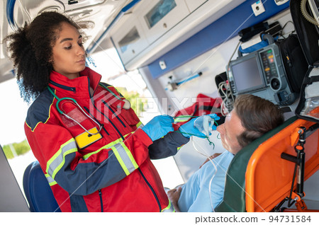 Ambulance doctor preparing a respiratory patient for oxygen therapy 94731584